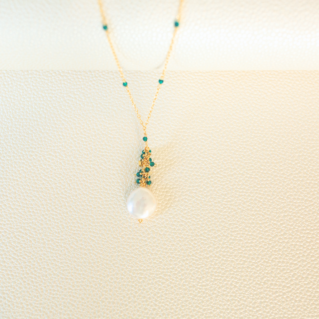 The Marea Pendant in London Blue Quartz and gold, showing the hand-wired gemstone cluster and freshwater coin pearl.
