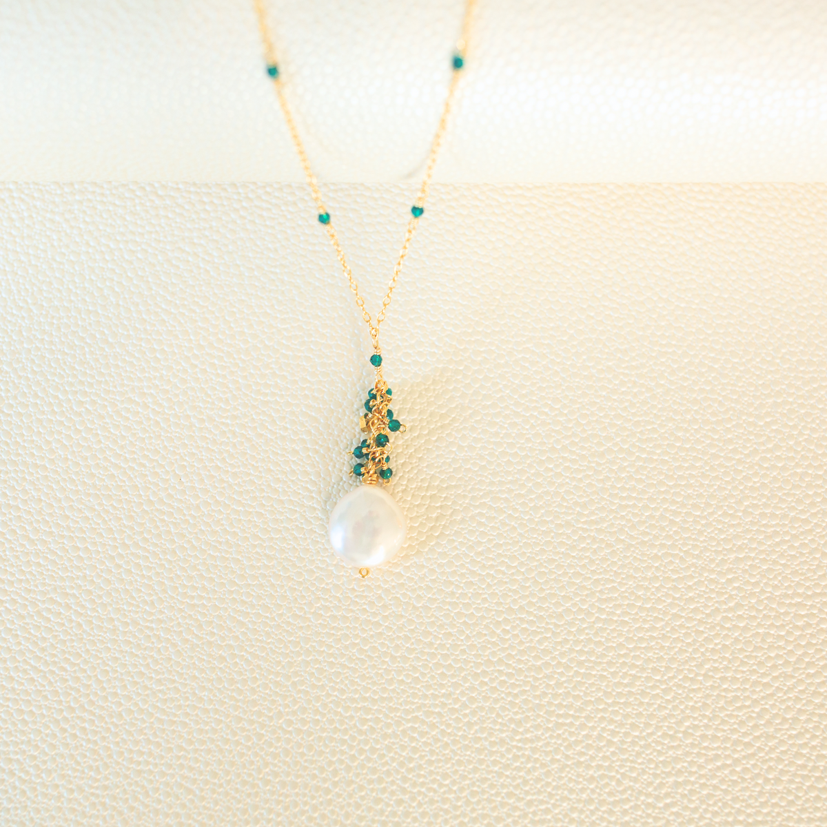 The Marea Pendant in London Blue Quartz and gold, showing the hand-wired gemstone cluster and freshwater coin pearl.