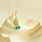 Aquamarine Solara Drops with aqua bead clusters, open gold circles and teal gemstone drops, shown in a closeup.