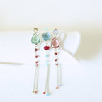 Green, blue and pink Isla gemstone bracelets arranged on a white display.