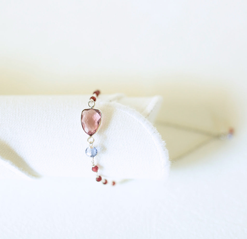 Pink gemstone Isla bracelet with silver-tone links and small beads on a white display.