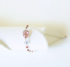 Pink gemstone Isla bracelet with silver-tone links and small beads on a white display.