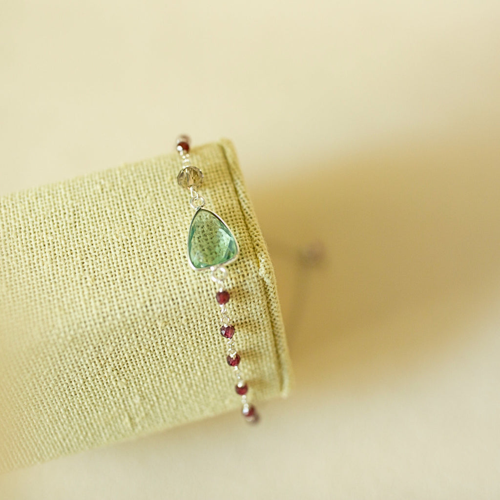 Pale green gemstone Isla bracelet with silver-tone links on a fabric display.
