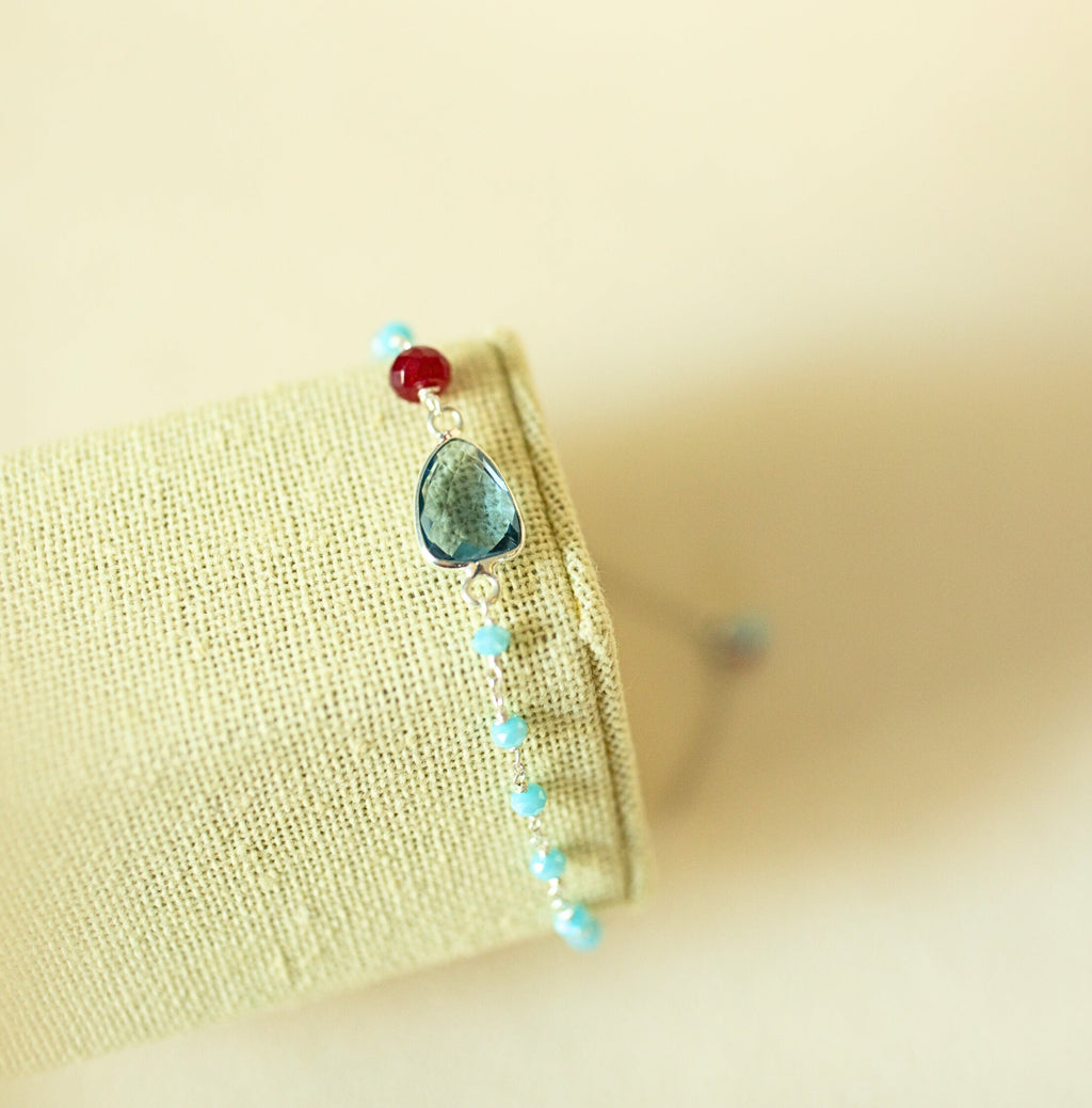Blue gemstone Isla bracelet with silver-tone links on a fabric display.