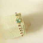 Pale green gemstone Isla bracelet with gold-tone links on a fabric display.