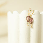 Pink gemstone Isla Drops with gold-tone hooks on a cream display.