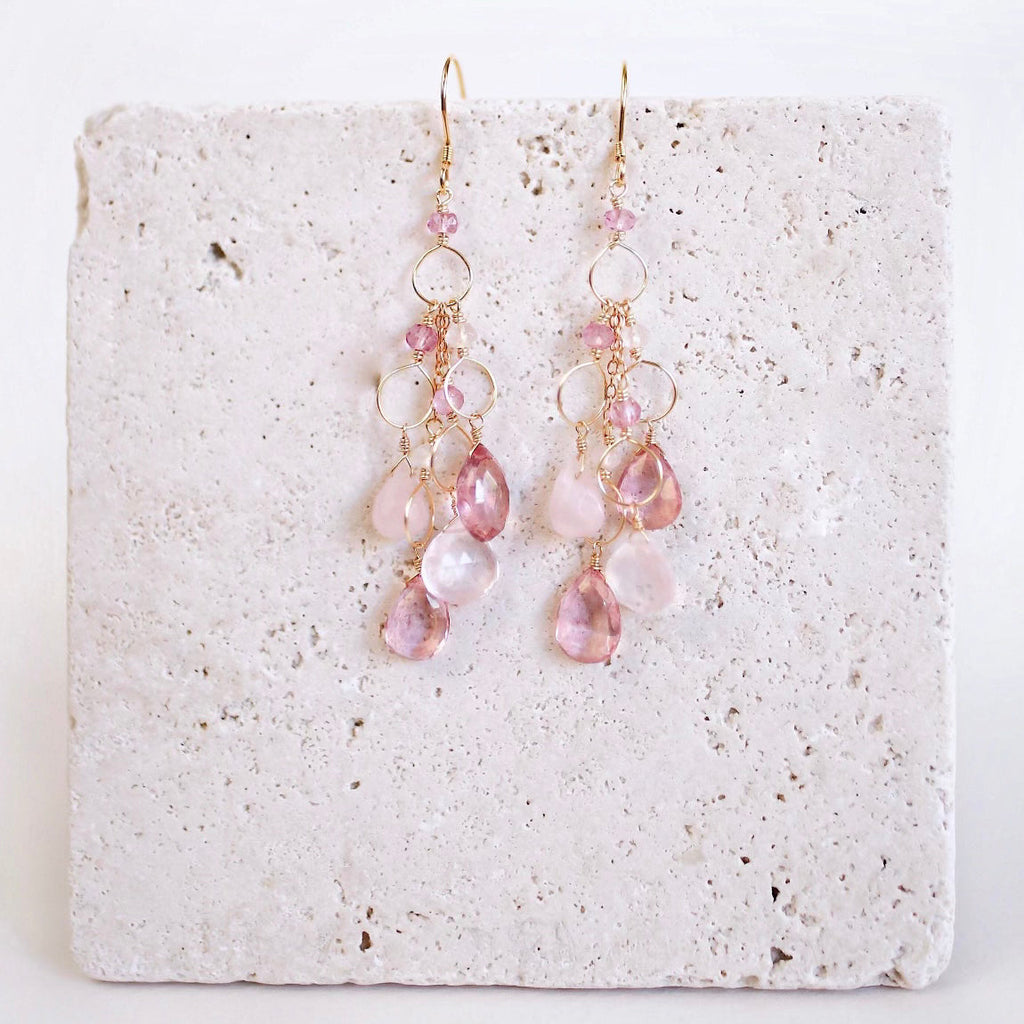 The Rosaline Drops with pink and pale gemstone drops and open gold circular links, shown on pale stone.