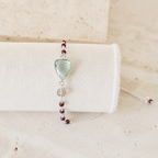 The Isla Bracelet in Green Amethyst and rhodium-plated silver, with red bead details on ivory linen