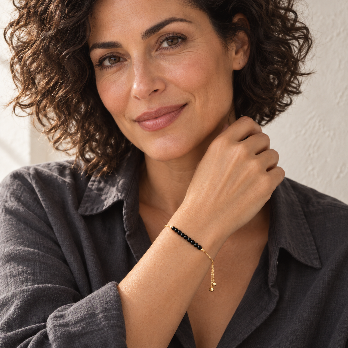The Essential Bracelet — Black Spinel styled on a model; AI-generated lifestyle image.