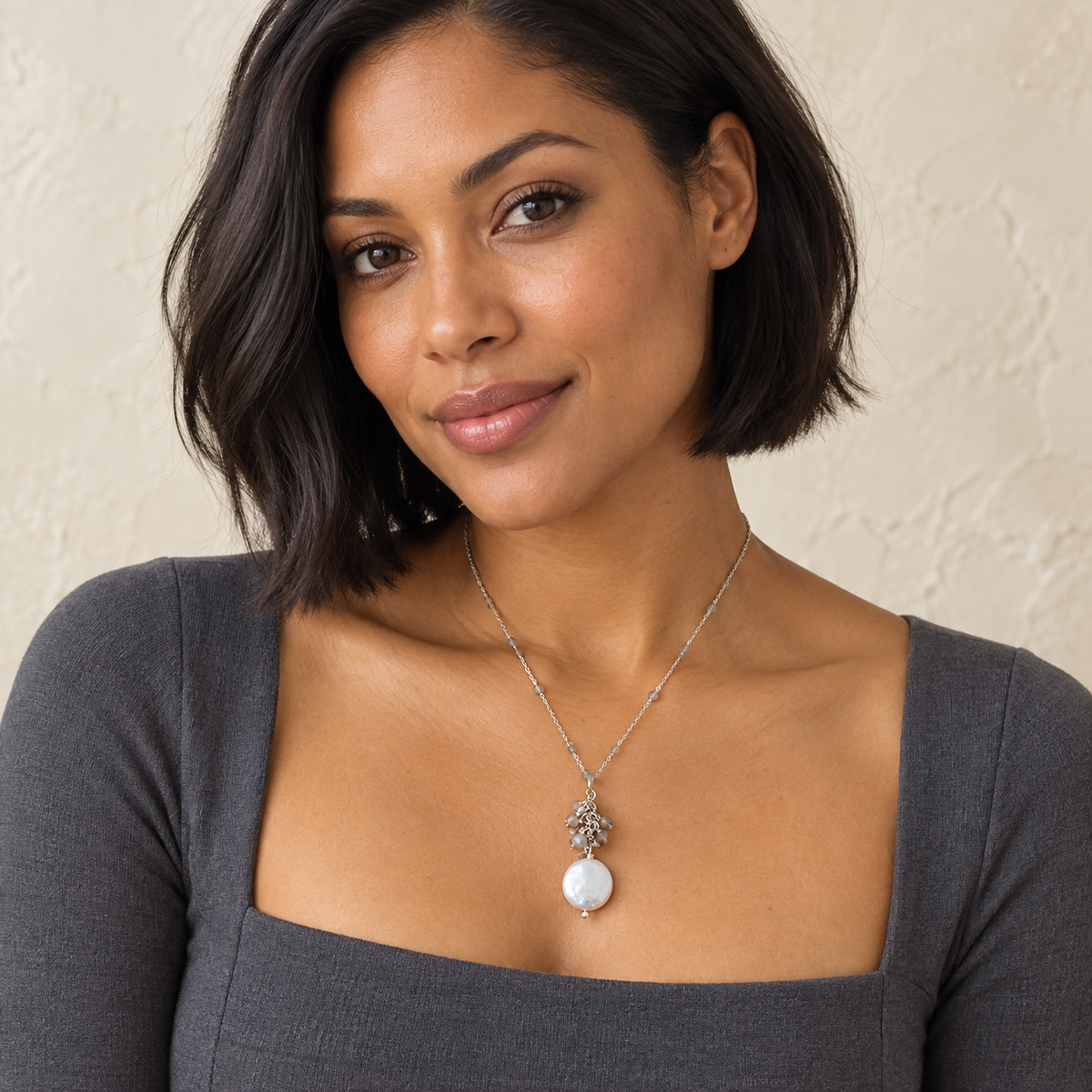 The Marea Pendant — Labradorite / Rhodium-plated Silver styled on a model; AI-generated lifestyle image.