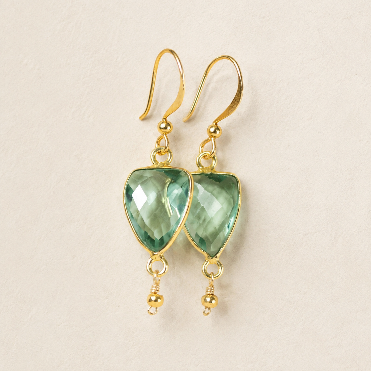 The Isla Drops in Green Amethyst — refined close-up of pale green faceted stones and gold-plated silver hooks.