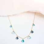 The Azzurra Necklace in gold, showing the arrangement of blue gemstone drops along the chain.